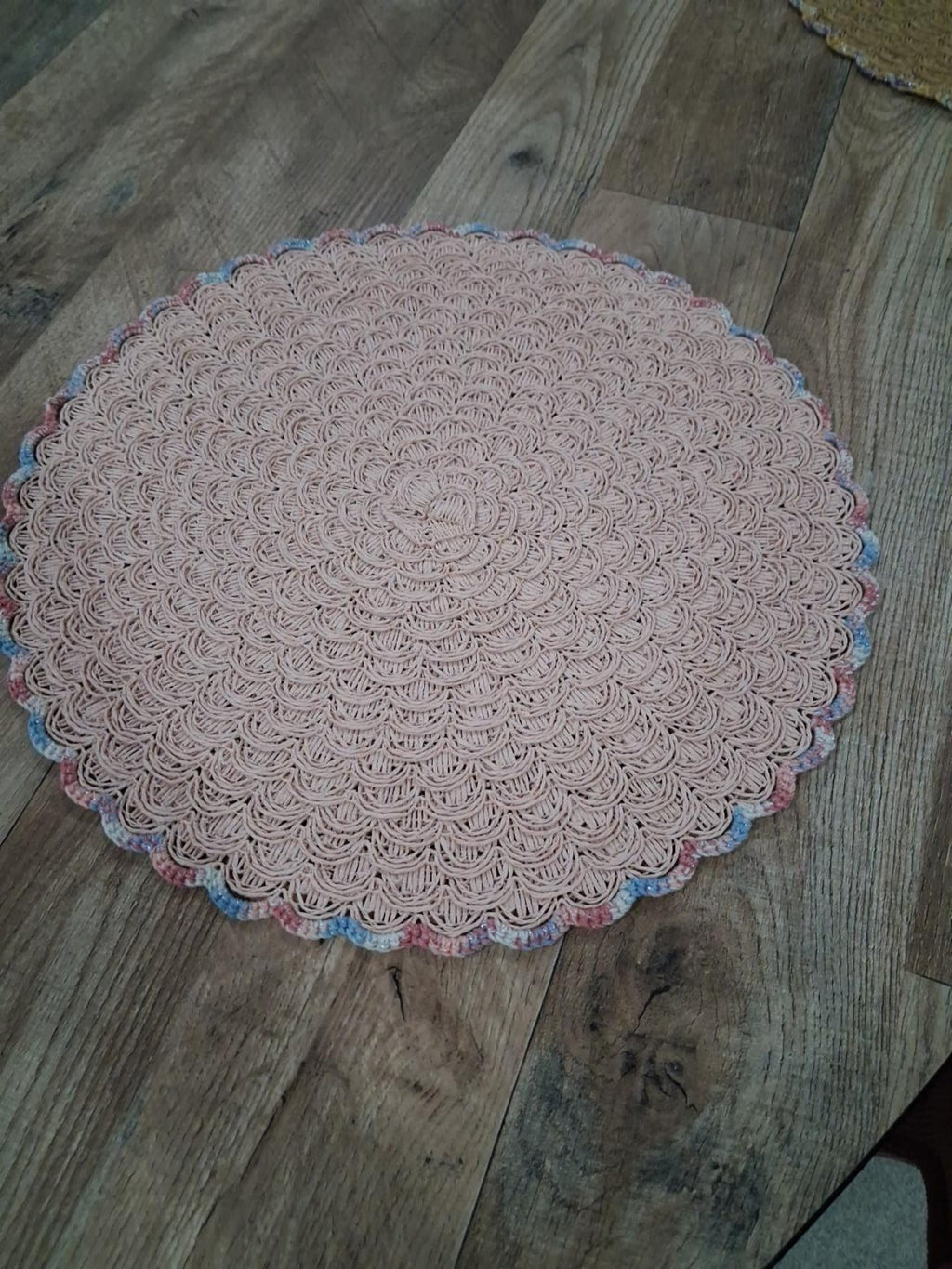 Fotografia real de base de mesa rosa-pálido com croché de conchas e bordadura multicolor