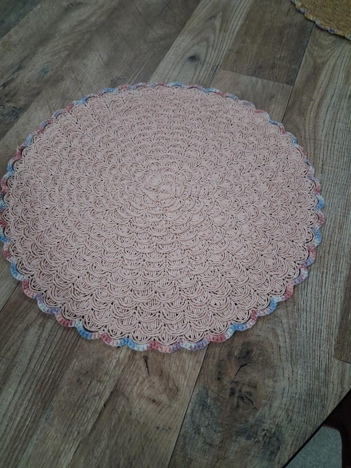 Fotografia real de base de mesa rosa-pálido com croché de conchas e bordadura multicolor
