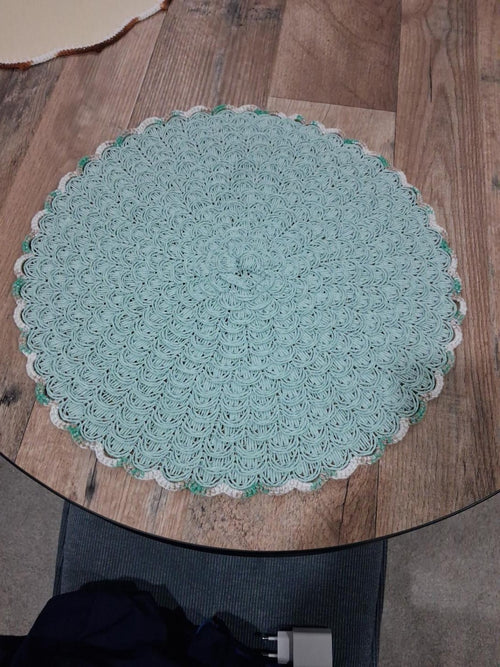 Fotografia original da base de mesa verde-água em croché com bordadura branca e verde